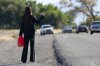 87308808-autostoppista-della-donna-mentre-tiene-un-gas-può.jpg